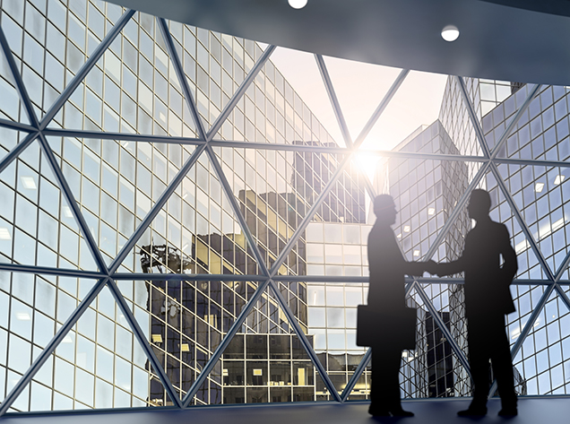 two men shaking hands by window