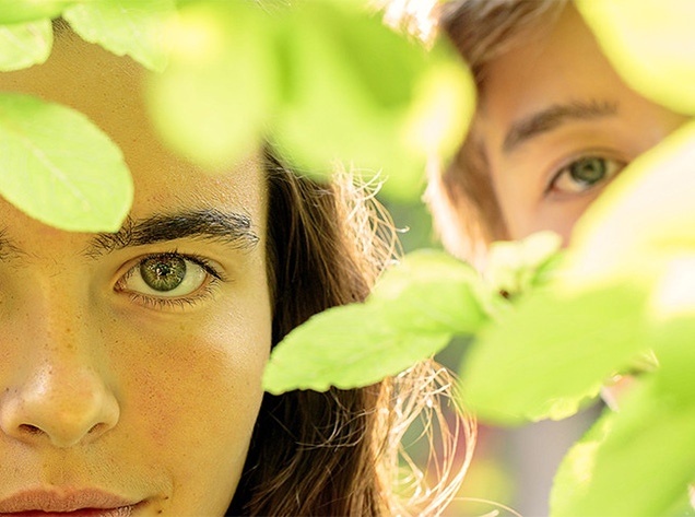 boy and girl behind tree