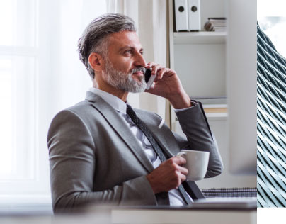 man on cell phone holding coffee cup